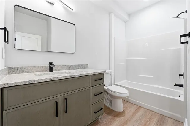 a bathroom with a granite countertop toilet sink and a mirror