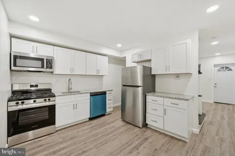 a kitchen with white cabinets and stainless steel appliances