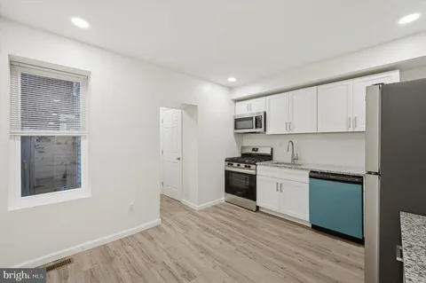 a kitchen with stainless steel appliances granite countertop a stove a sink and a refrigerator