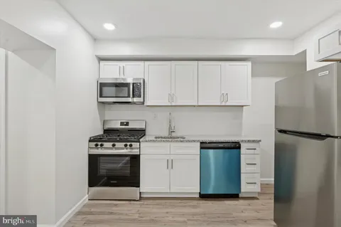 a kitchen with a stove top oven and refrigerator