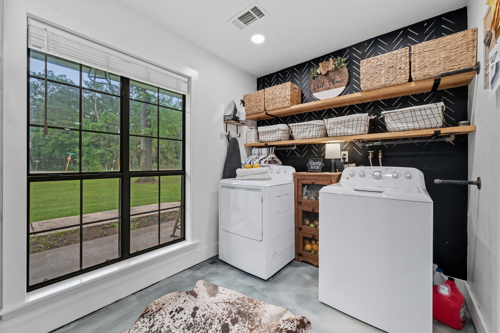 18 East Old Field Road Huffman, TX 77336 - Photo 15 of 35 The combined walk-in pantry and utility room is thoughtfully designed featuring open shelving, convenient hanging storage, and a large window overlooking the lush yard that fills the space with natural light.