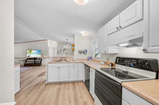 a kitchen with a sink a stove and cabinets