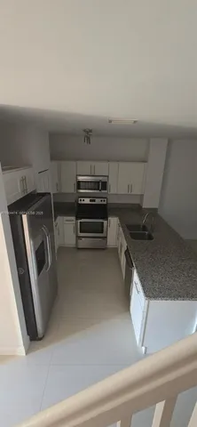 a kitchen with a refrigerator and a sink