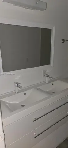 a view of a room with wooden floor and a ceiling fan