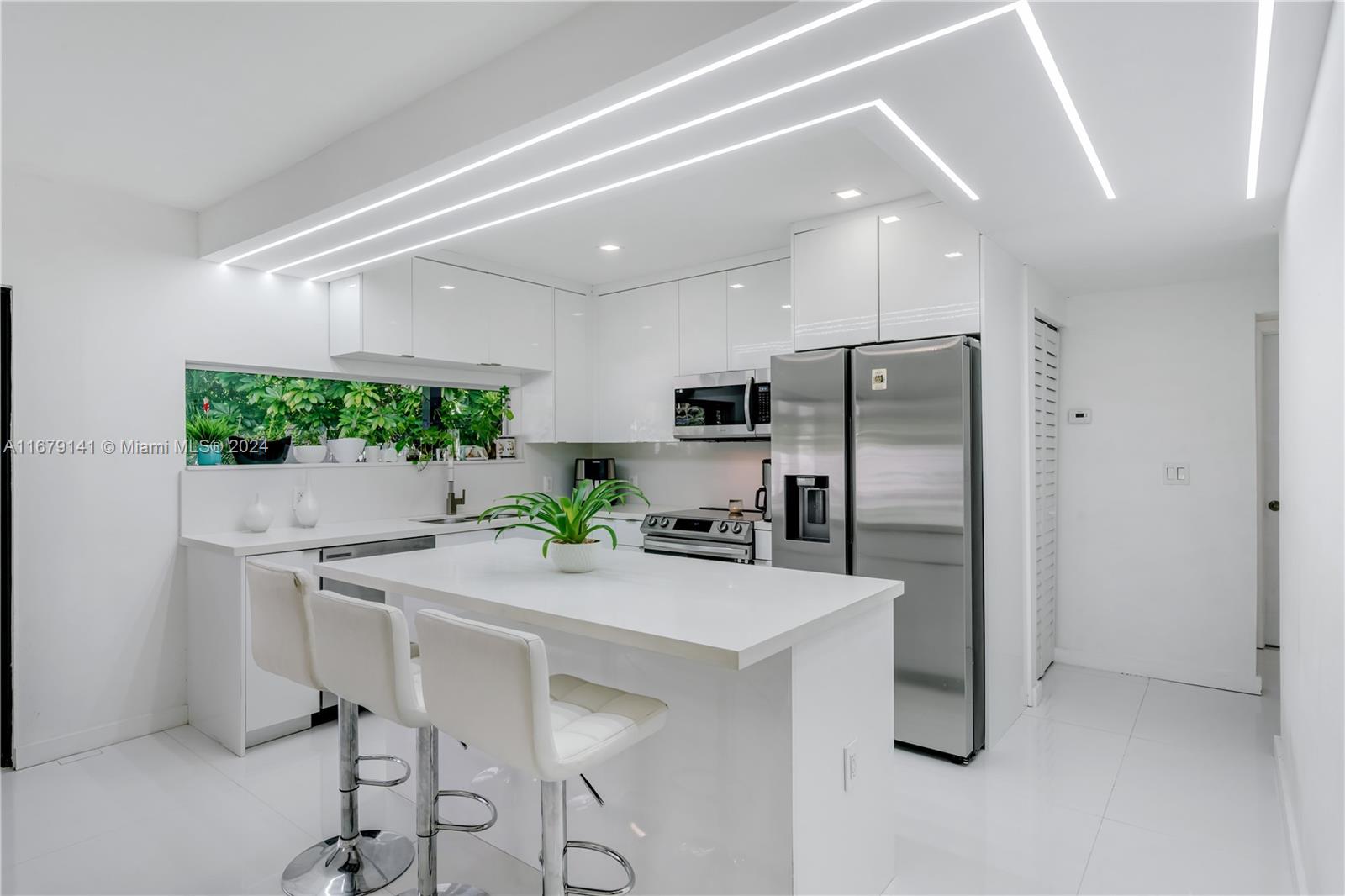 6101 Southwest 44th Terrace Miami, FL 33155 - Photo 5 of 24 a kitchen with stainless steel appliances a microwave a stove a refrigerator and a dining table