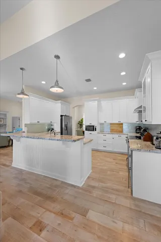 a spacious bedroom with a bed and a chandelier