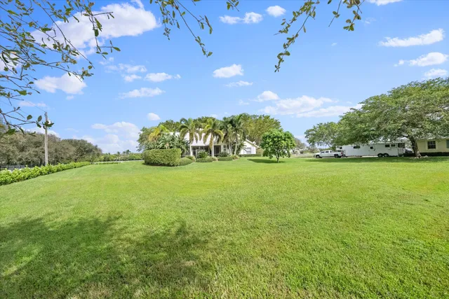 a view of a house with a yard and tree s