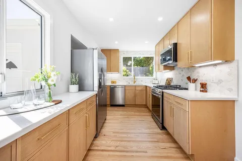 a kitchen with stainless steel appliances kitchen island granite countertop a sink and cabinets