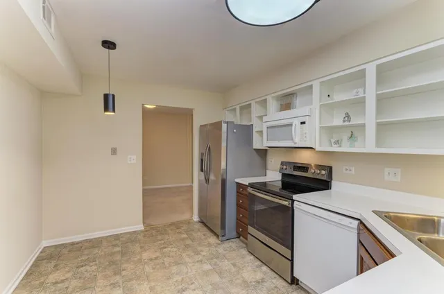 a kitchen with stainless steel appliances a stove a refrigerator and a cabinets