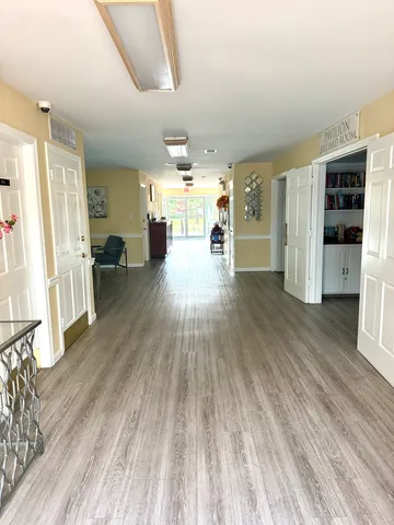 a room with wooden floor pool table and a window