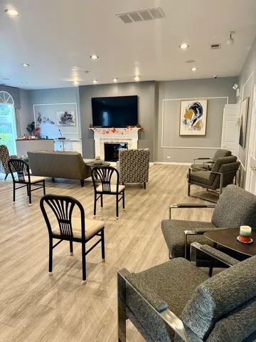 a living room with furniture a flat screen tv and kitchen view