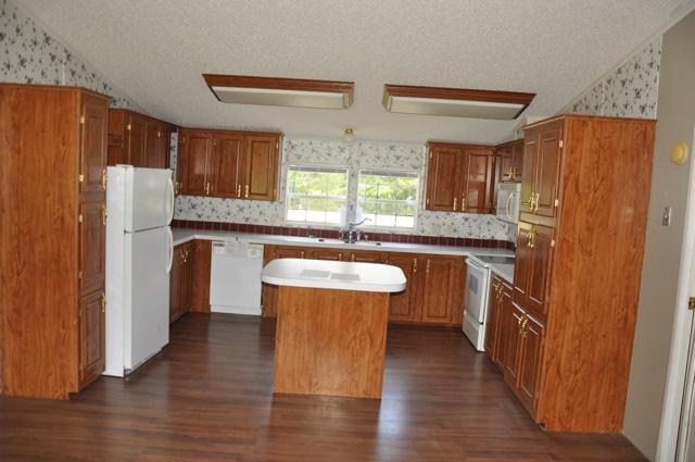 72 Arbour Street DeFuniak Springs, FL 32433 - Photo 5 of 13 a kitchen with kitchen island wooden floors appliances and window