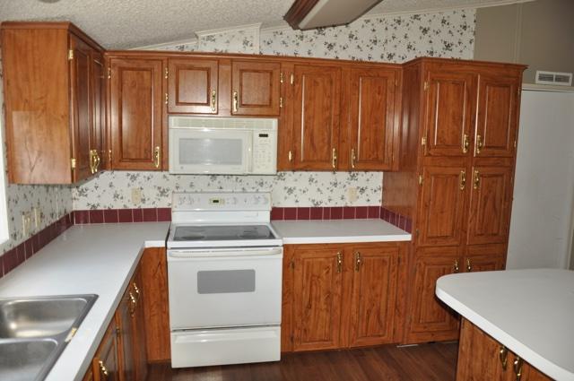72 Arbour Street DeFuniak Springs, FL 32433 - Photo 6 of 13 a kitchen with wooden cabinets and a stove top oven