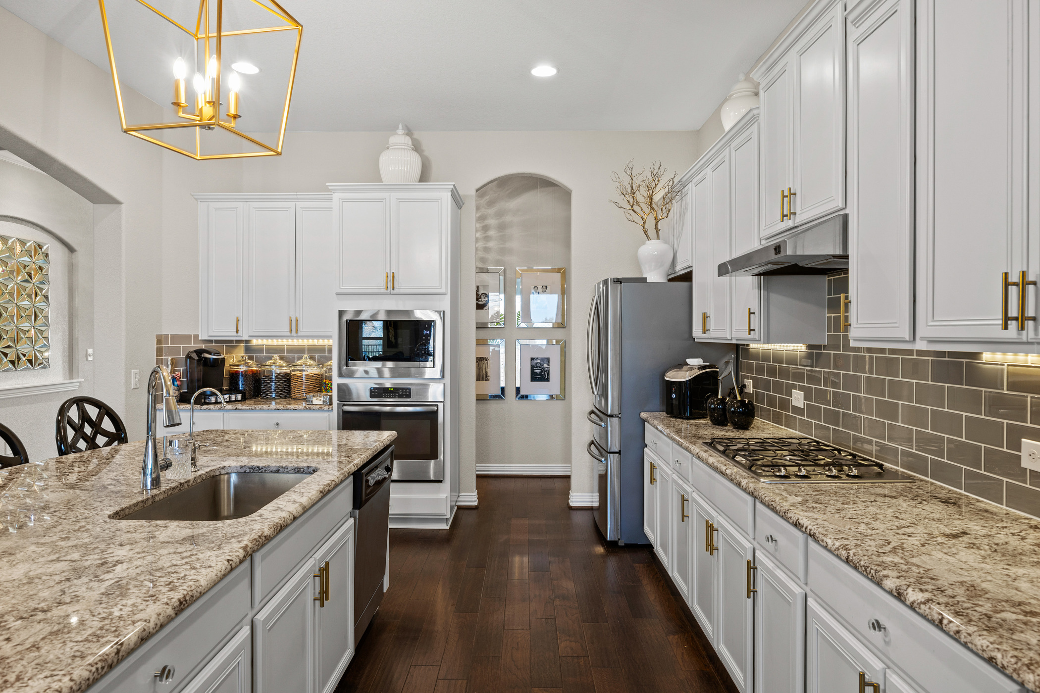 381 Betony Loop Buda, TX 78610 - Photo 6 of 32 a kitchen with stainless steel appliances granite countertop a sink stove and refrigerator