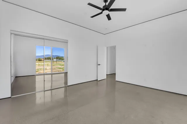 a view of a hallway with wooden floor and a bathroom