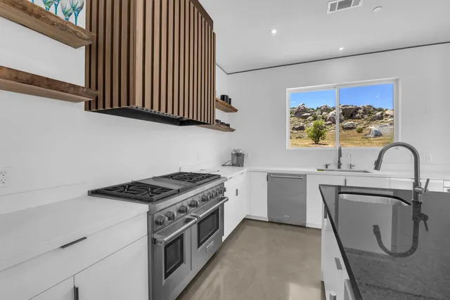 an empty room with windows and ceiling fan