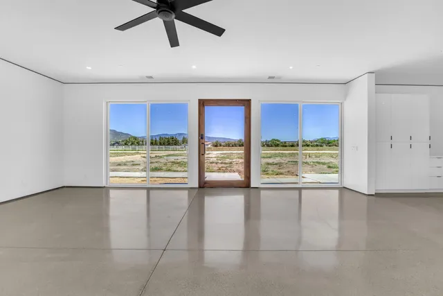 a view of empty room with a floor to ceiling window and ceiling fan