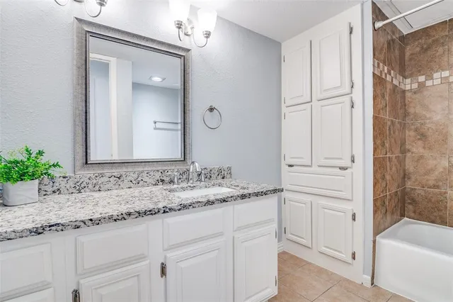 an empty room with wooden floor chandelier fan and windows