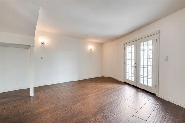 a view of an empty room with wooden floor fireplace and a window
