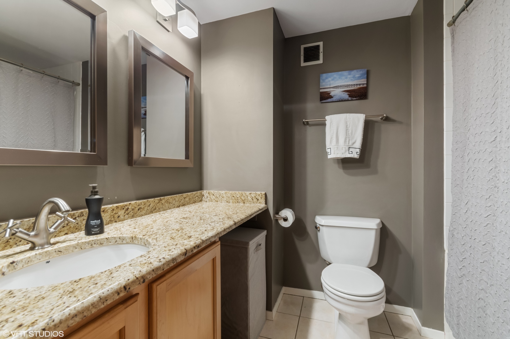 1250 West Van Buren Street, Unit 605 Chicago, IL 60607 - Photo 14 of 16 a bathroom with a granite countertop toilet sink and mirror