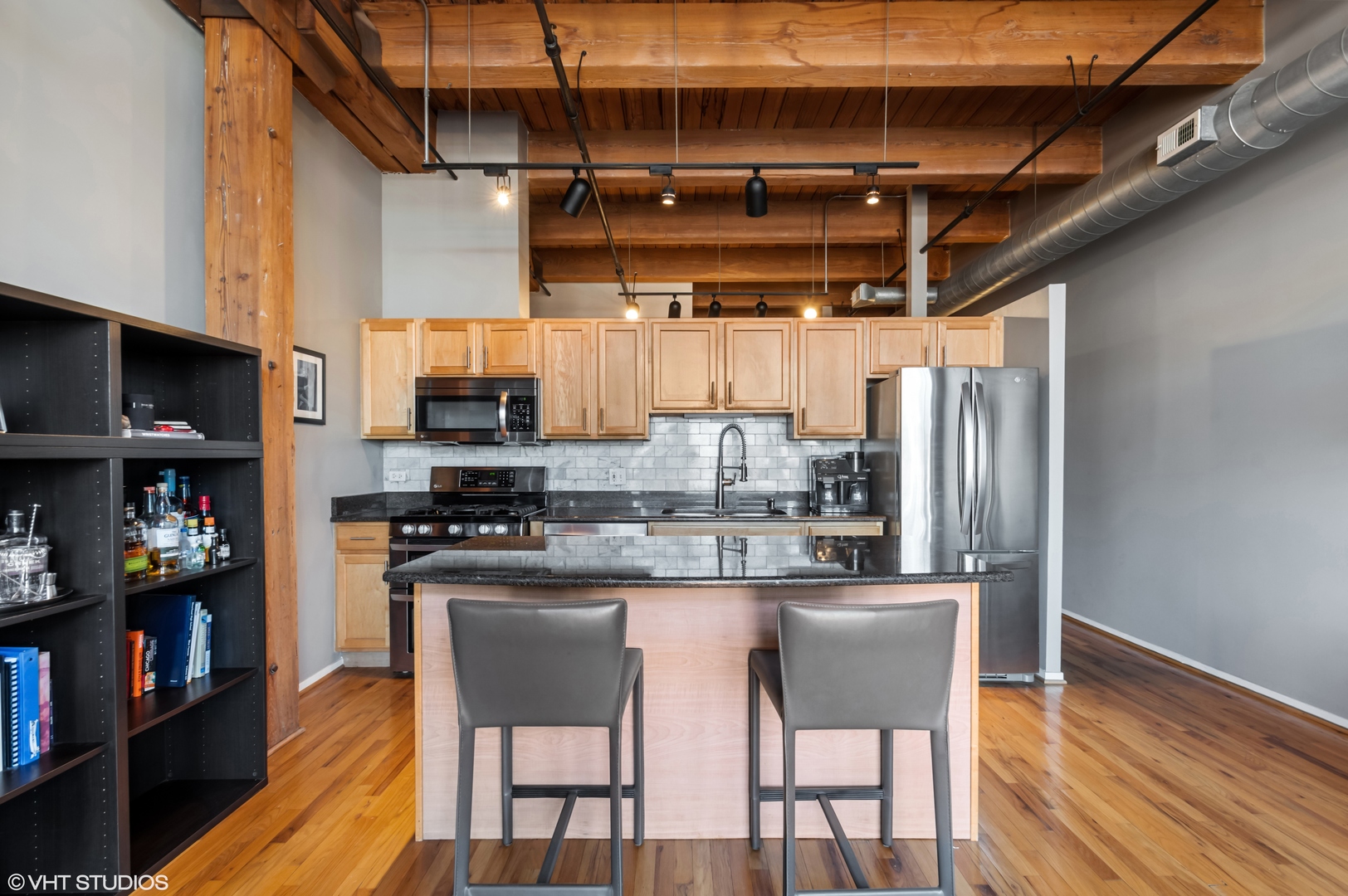 1250 West Van Buren Street, Unit 605 Chicago, IL 60607 - Photo 7 of 16 a kitchen with stainless steel appliances granite countertop a table chairs sink and cabinets