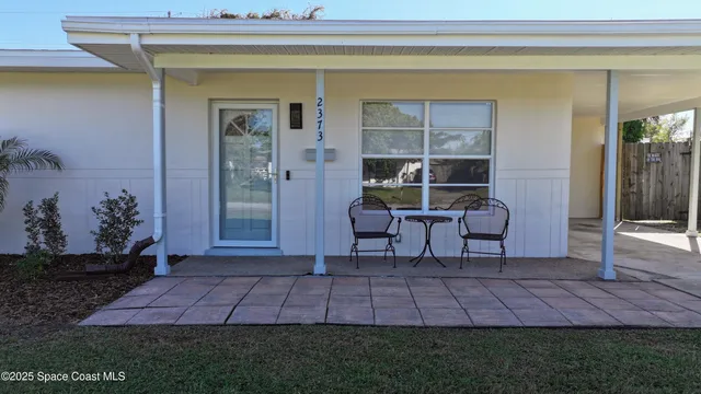 a view of a patio with table and chairs and potted plants