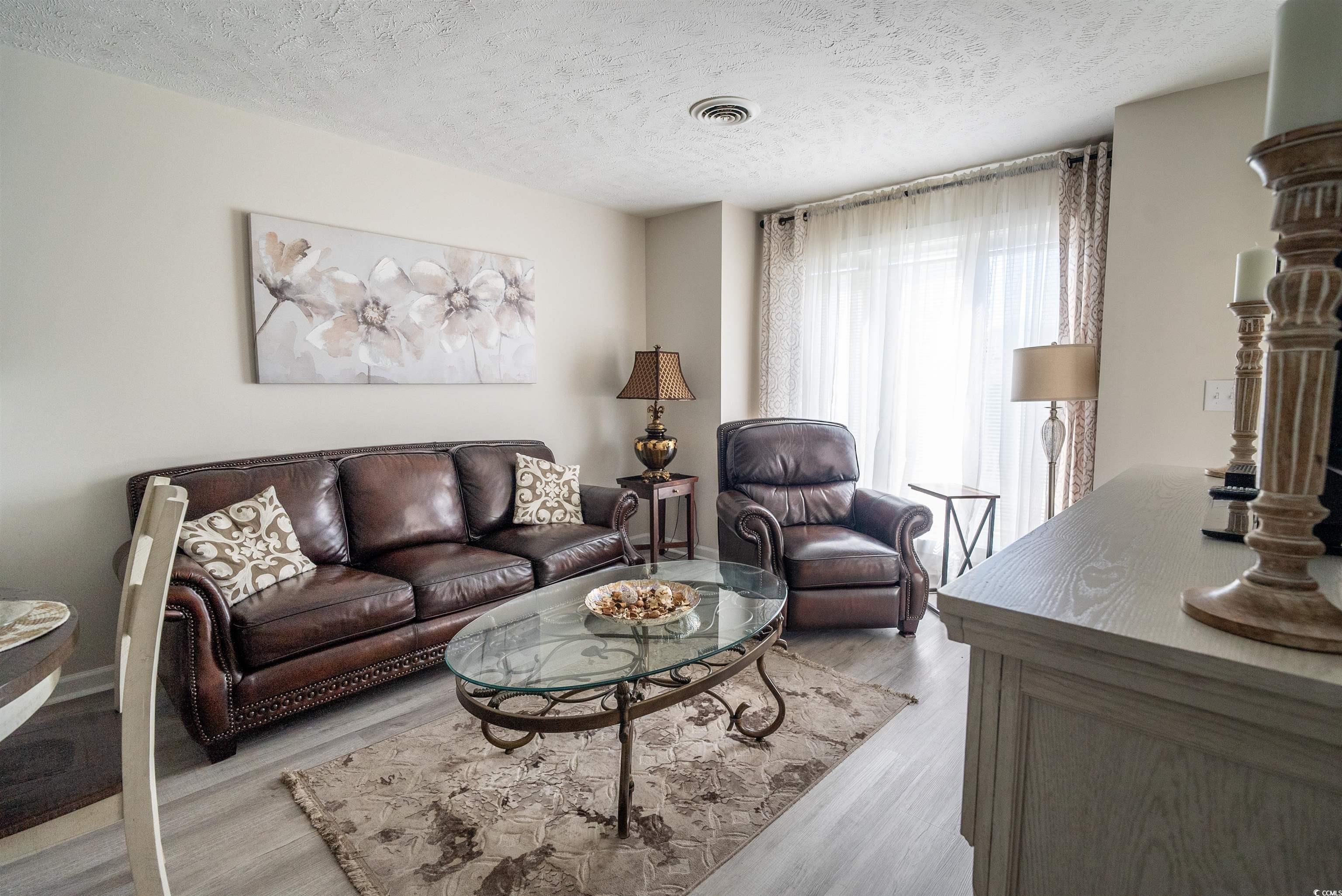 4715 Cobblestone Drive Myrtle Beach, SC 29577 - Photo 5 of 12 Living area featuring a textured ceiling and light wood-type flooring