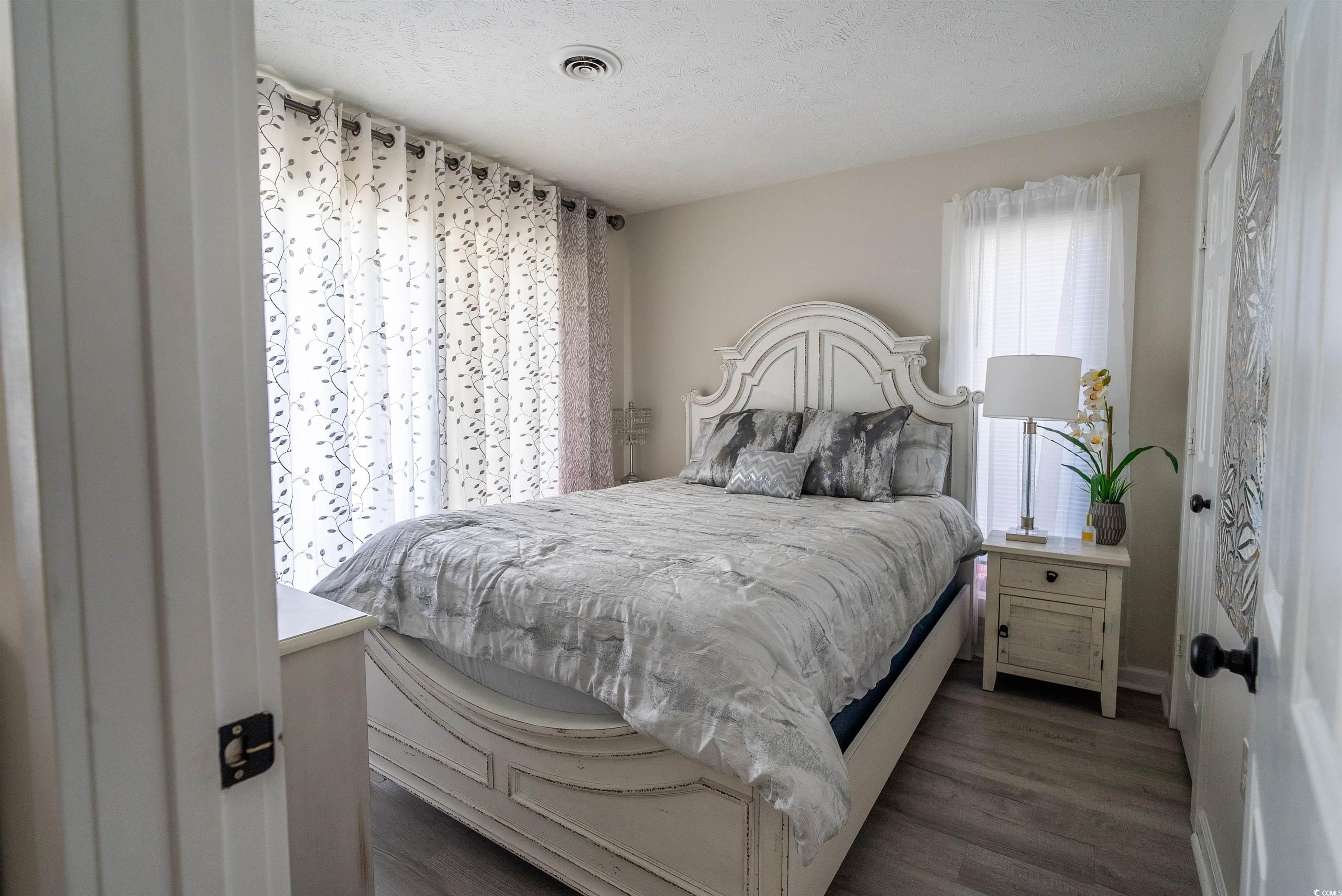 4715 Cobblestone Drive Myrtle Beach, SC 29577 - Photo 9 of 12 Bedroom featuring dark wood finished floors and a textured ceiling