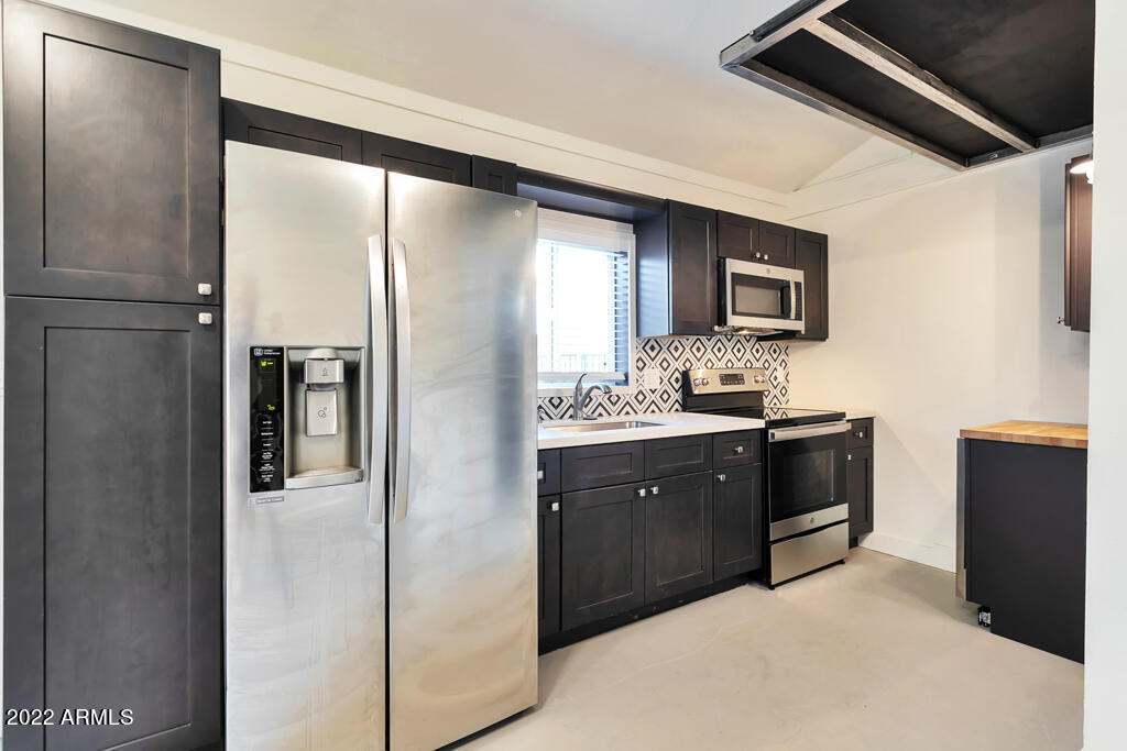 1638 East Granada Road, Unit B Phoenix, AZ 85006 - Photo 3 of 19 a kitchen with stainless steel appliances granite countertop a refrigerator and a stove top oven