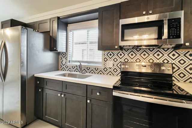 a kitchen with stainless steel appliances a stove microwave and refrigerator