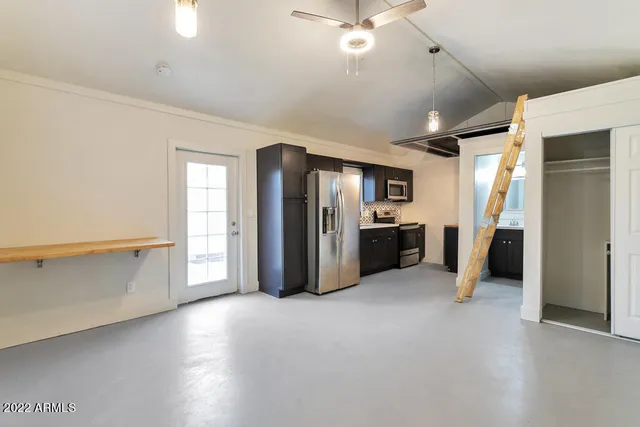 an empty room with windows and ceiling fan