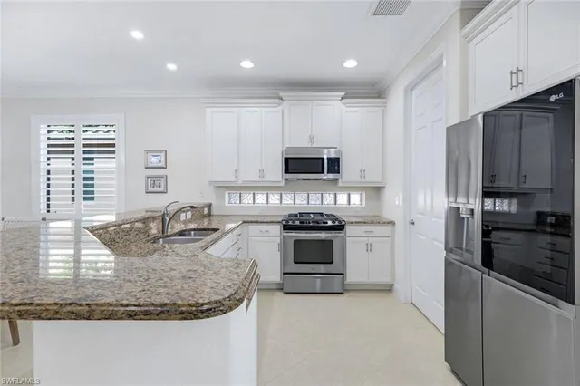 a kitchen with kitchen island granite countertop a stove sink and microwave