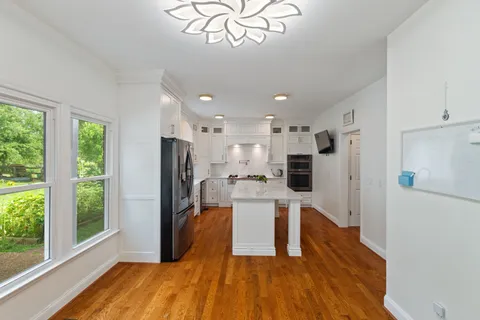 a kitchen with white cabinets and appliances