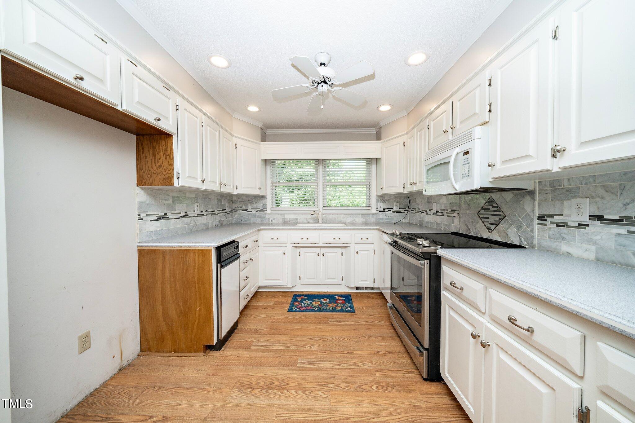 10213 Jordan Road Raleigh, NC 27603 - Photo 14 of 62 a kitchen with stainless steel appliances granite countertop a white cabinets and window