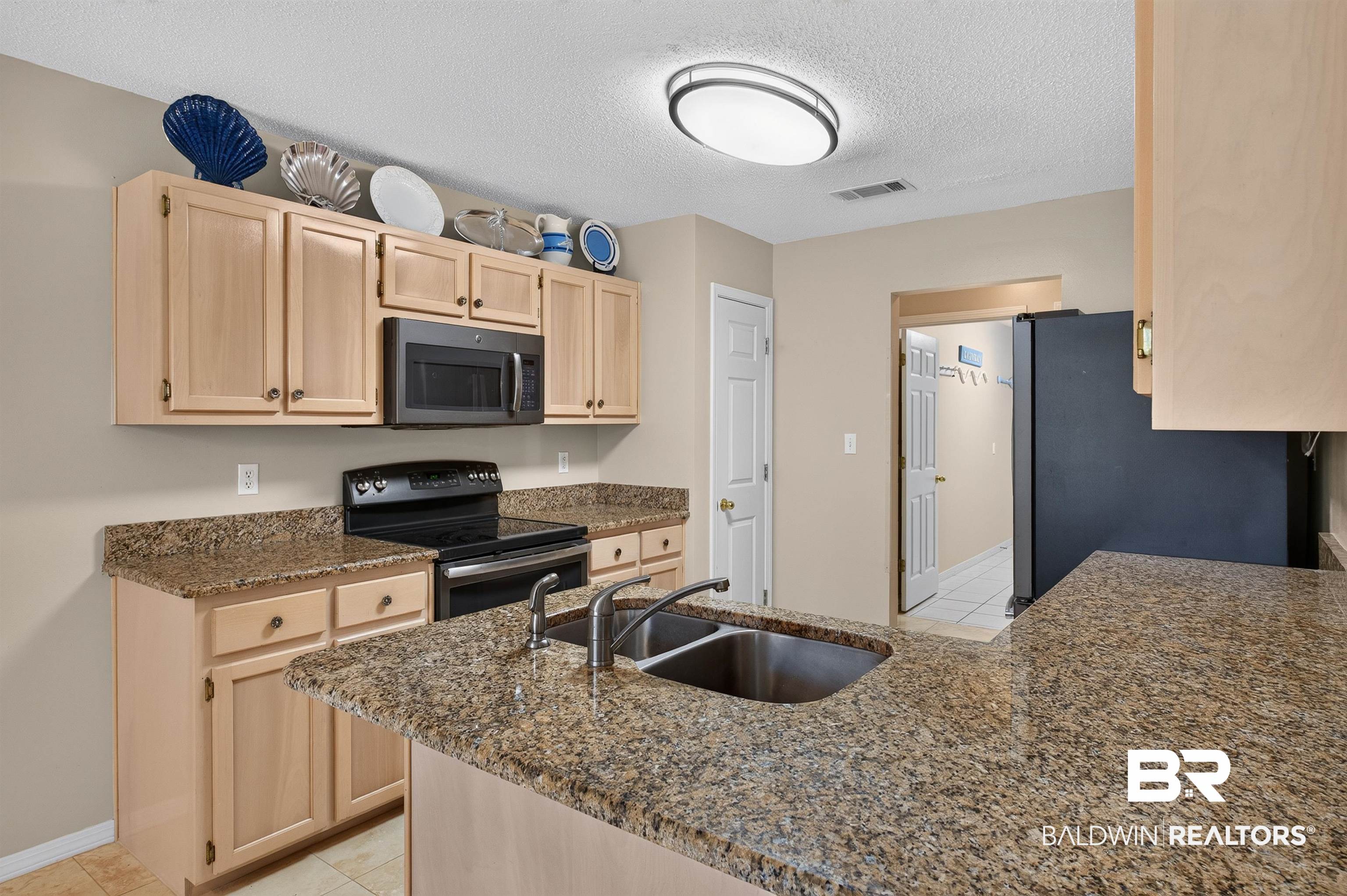 22685 County Road 12 Foley, AL 36535 - Photo 42 of 89 Kitchen featuring a dual basin sink, light wood-finish cabinetry, black appliances, and granite-style countertops