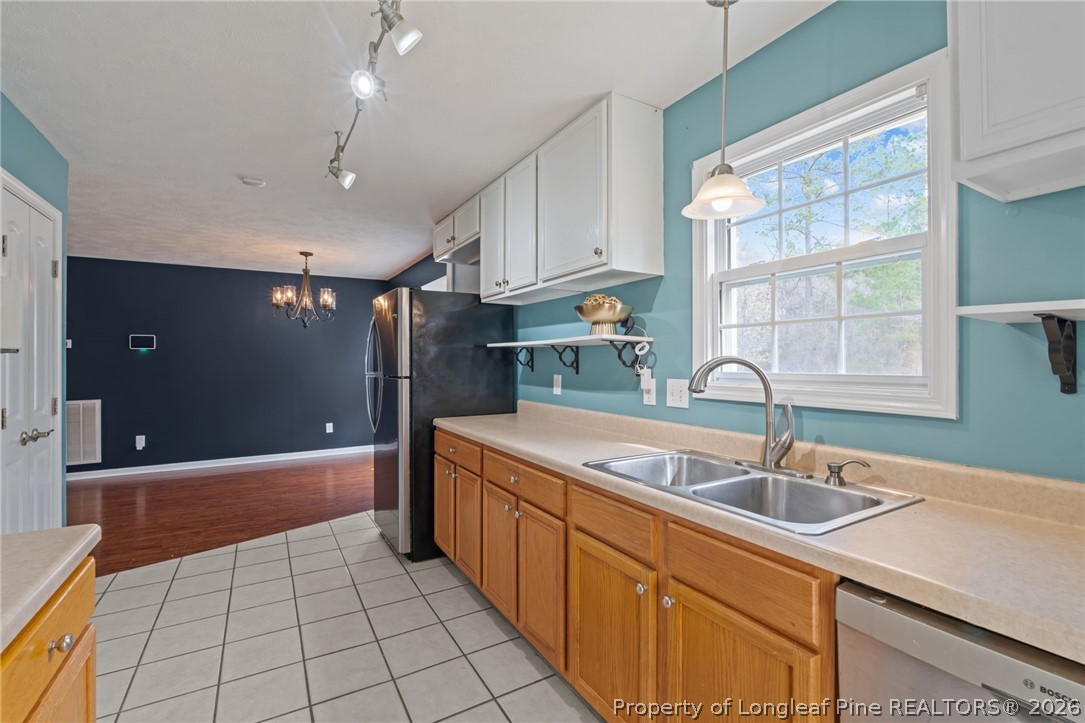 115 Shelby Street Spring Lake, NC 28390 - Photo 19 of 40 a kitchen with a sink a counter top space cabinets and a window
