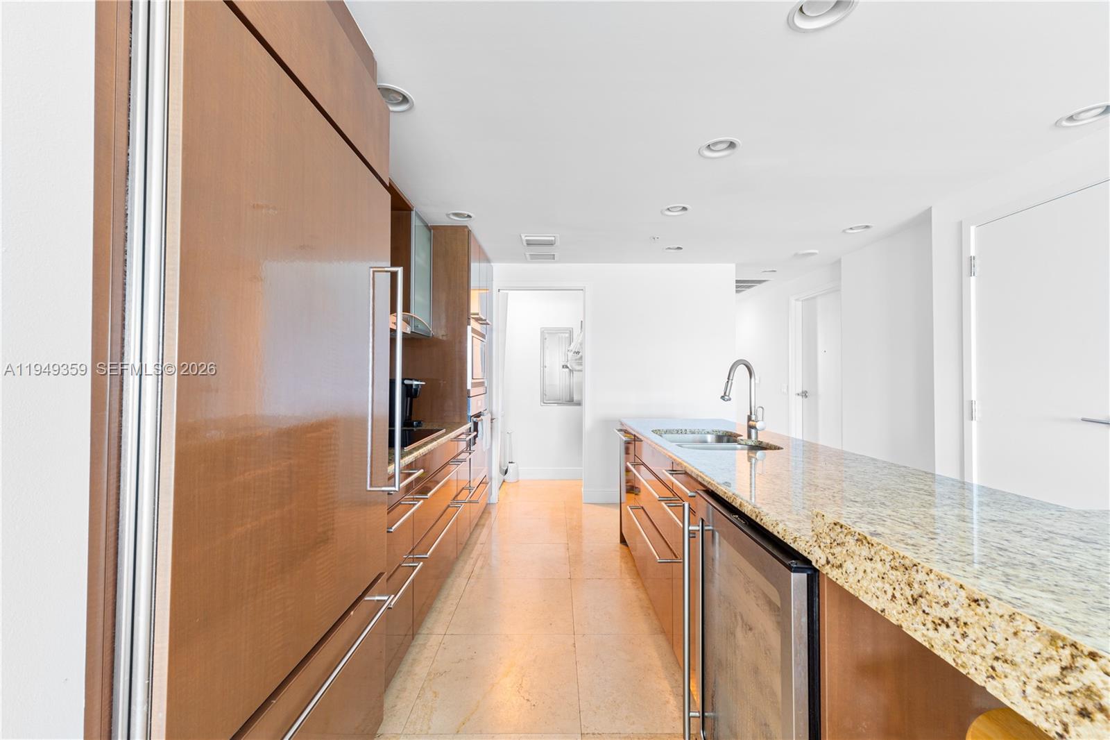 3801 Collins Avenue, Unit 1105 Miami Beach, FL 33140 - Photo 15 of 44 a large kitchen with kitchen island granite countertop a sink and wooden floor