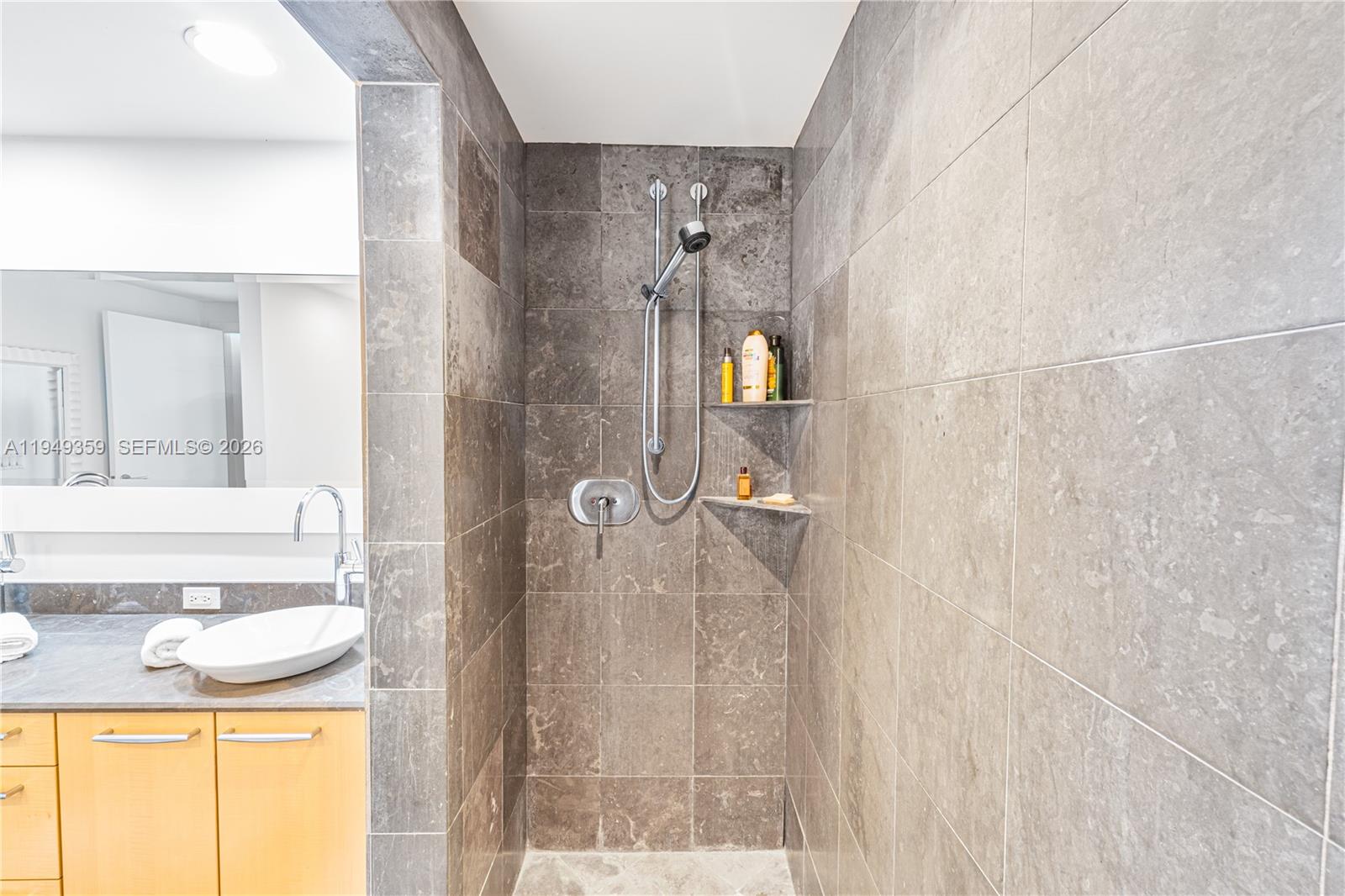 3801 Collins Avenue, Unit 1105 Miami Beach, FL 33140 - Photo 30 of 44 a bathroom with a granite countertop sink and a mirror