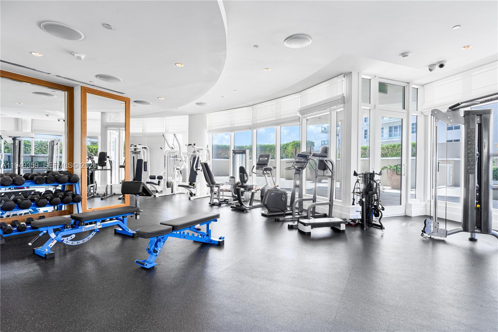 3801 Collins Avenue, Unit 1105 Miami Beach, FL 33140 - Photo 38 of 44 a view of a room with gym equipment and large windows