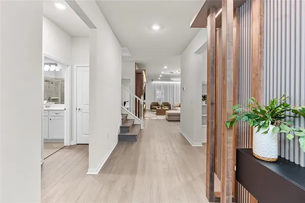 a view of a hallway with entryway wooden floor and a front door