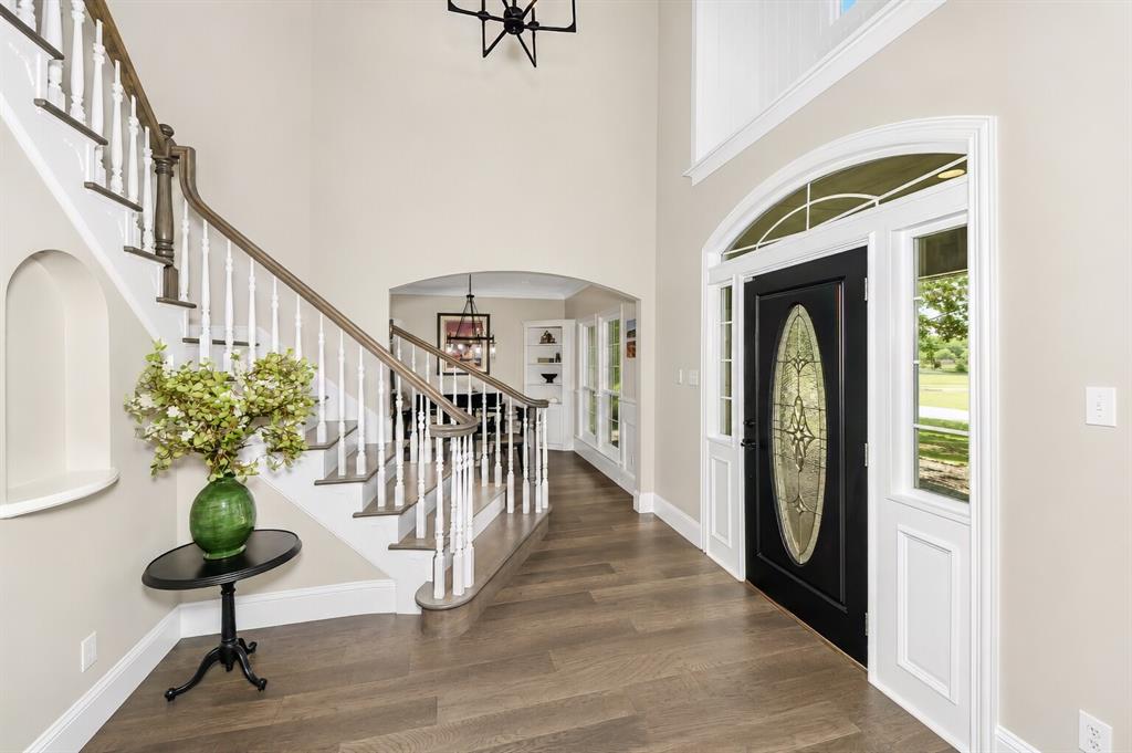 3817 Ganzer Road West Denton, TX 76207 - Photo 7 of 40 From the dining room, the foyer opens to a curved staircase that becomes the main architectural moment of the entry. The lines stay clean and bright, with natural light carrying through to the back of the house where the den sits. It’s a simple, welcoming transition that shows off the flow of the home without giving away the full den setup just yet.