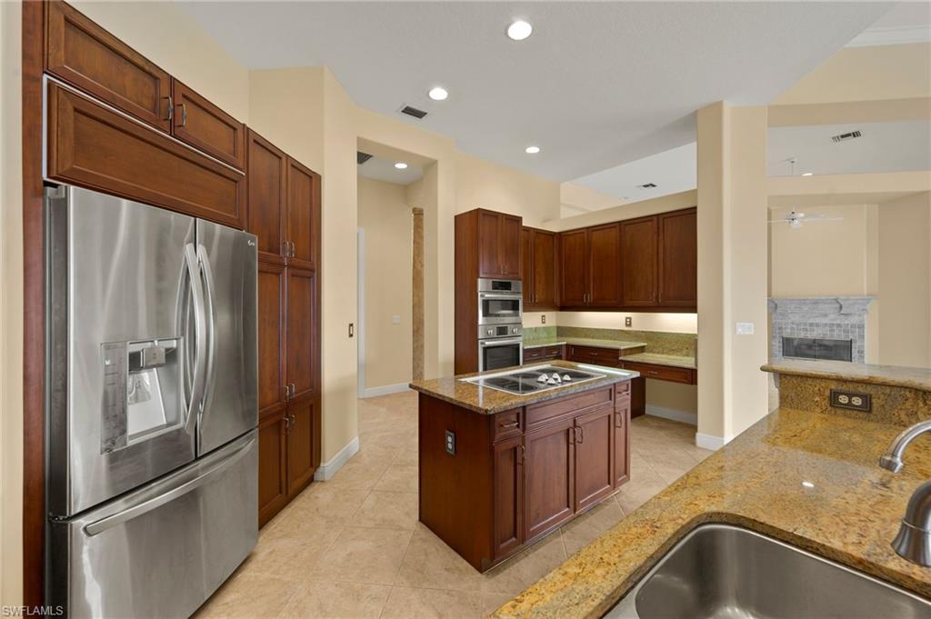 527 Terracina Way Naples, FL 34119 - Photo 19 of 48 a kitchen with stainless steel appliances granite countertop a refrigerator a stove and a sink