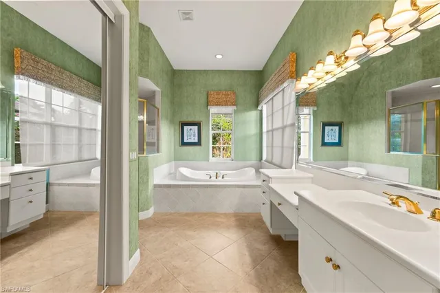 a bathroom with a tub shower and windows