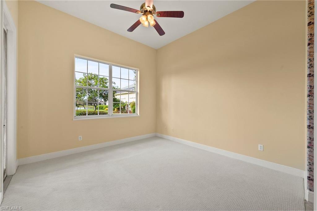 527 Terracina Way Naples, FL 34119 - Photo 34 of 48 an empty room with windows and chandelier fan