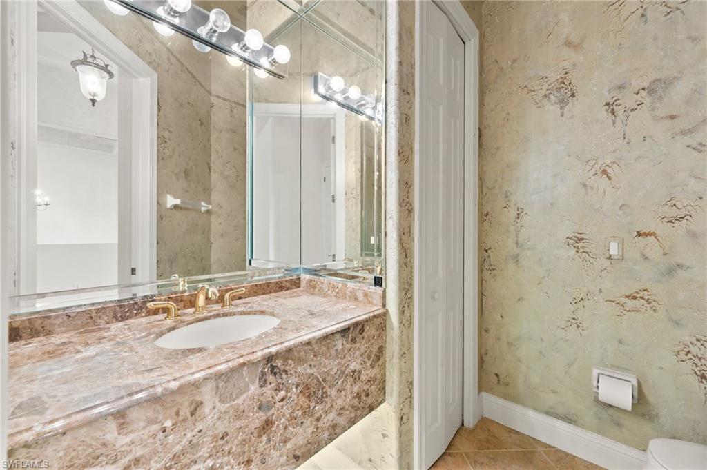 527 Terracina Way Naples, FL 34119 - Photo 37 of 48 a bathroom with a granite countertop sink a mirror and shower