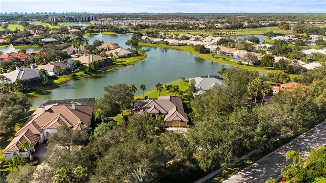 an aerial view of city and lake with trees all around