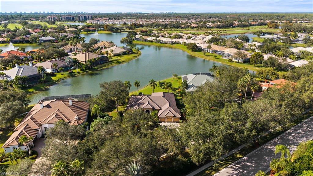 527 Terracina Way Naples, FL 34119 - Photo 9 of 48 an aerial view of city and lake with trees all around