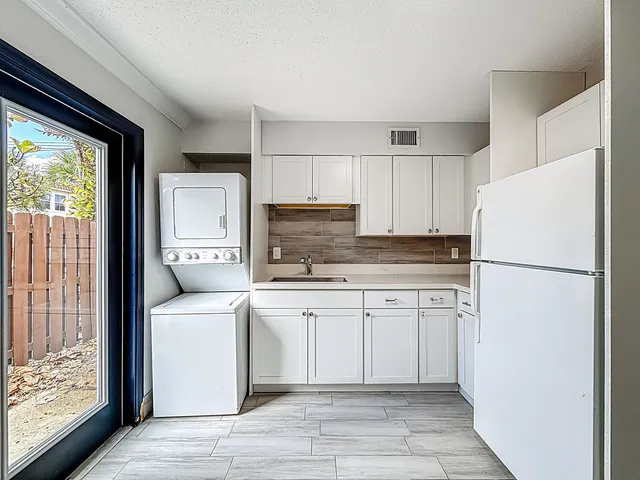 a kitchen with a refrigerator sink stove and cabinets