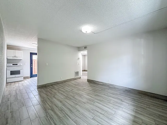 a view of an empty room with wooden floor