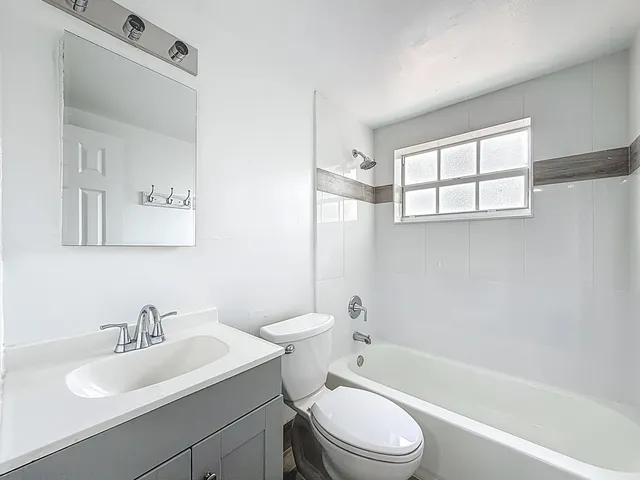 a bathroom with a sink toilet a mirror and shower